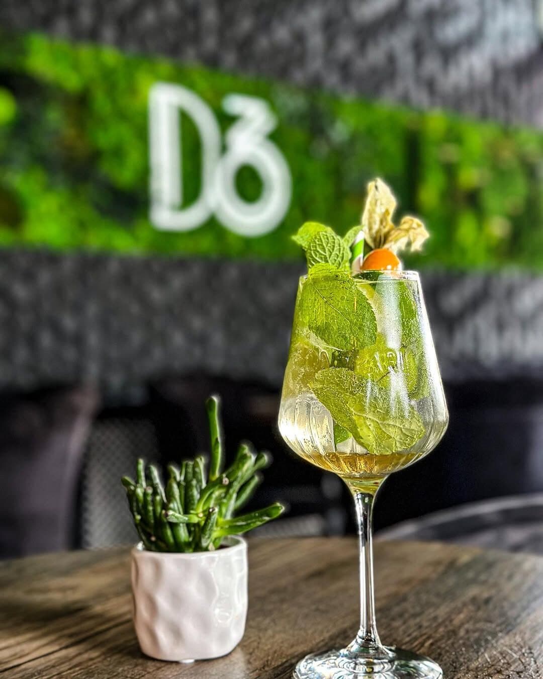 Cocktail verde în fața peretelui de mușchi cu semnul D36.