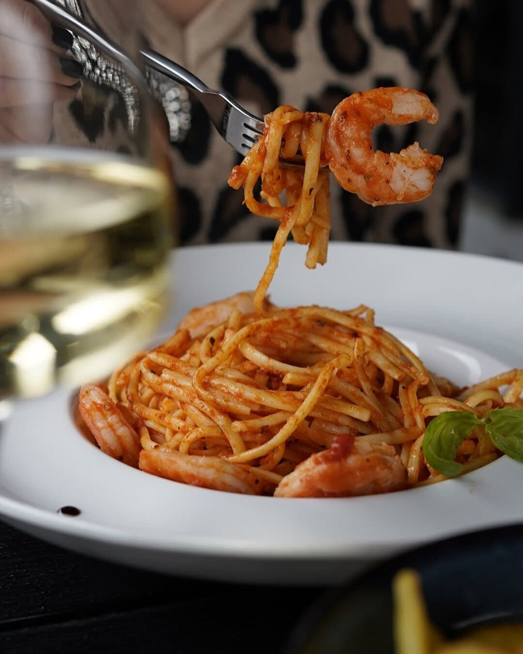 Spaghete cu creveți, ridicate cu furculița.